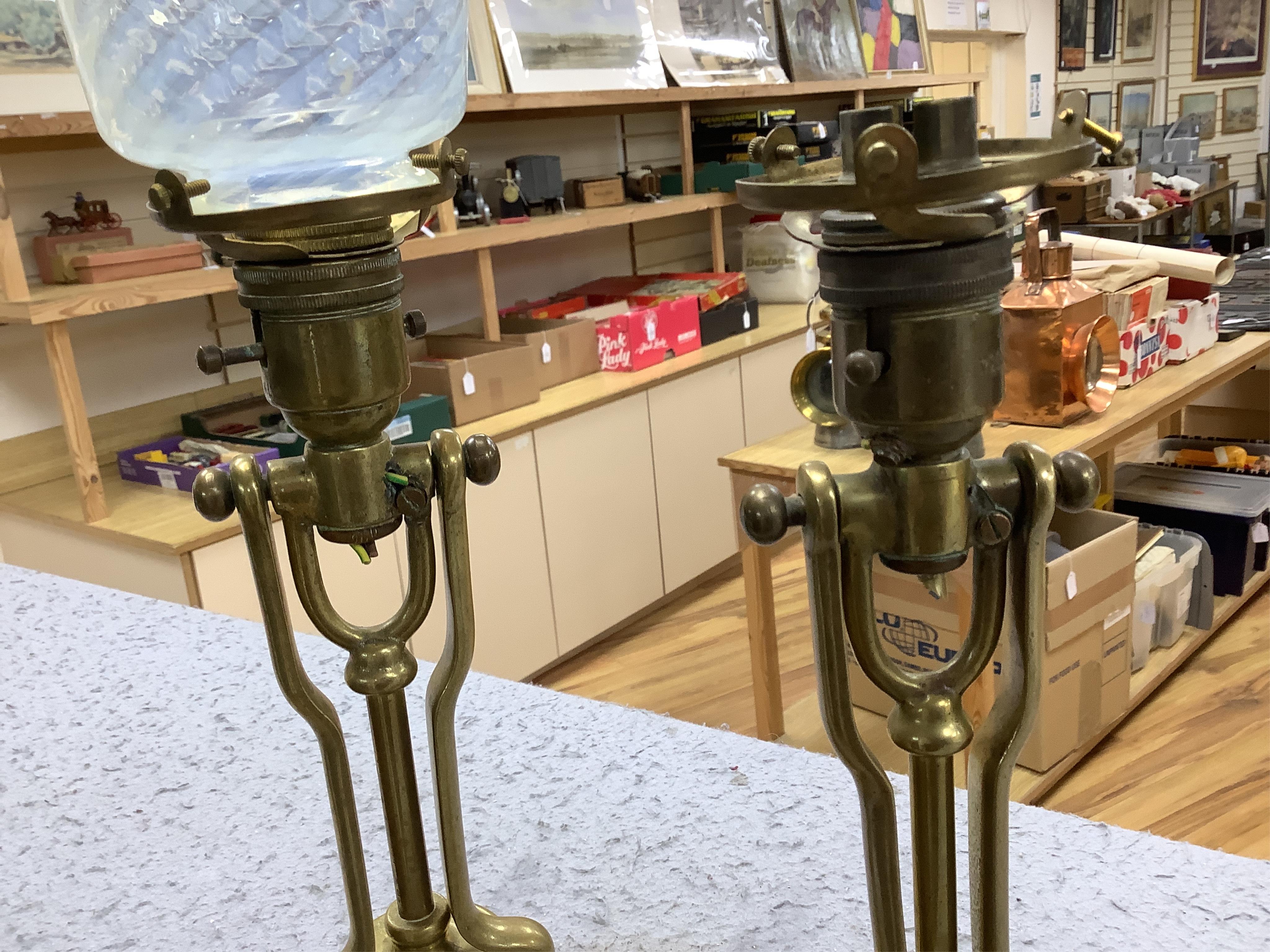 A pair of brass Pullman lamps with gimbal stems and Vaseline glass shades, modelled for wall mounting or freestanding, height to top of shade 40cm. Condition - good